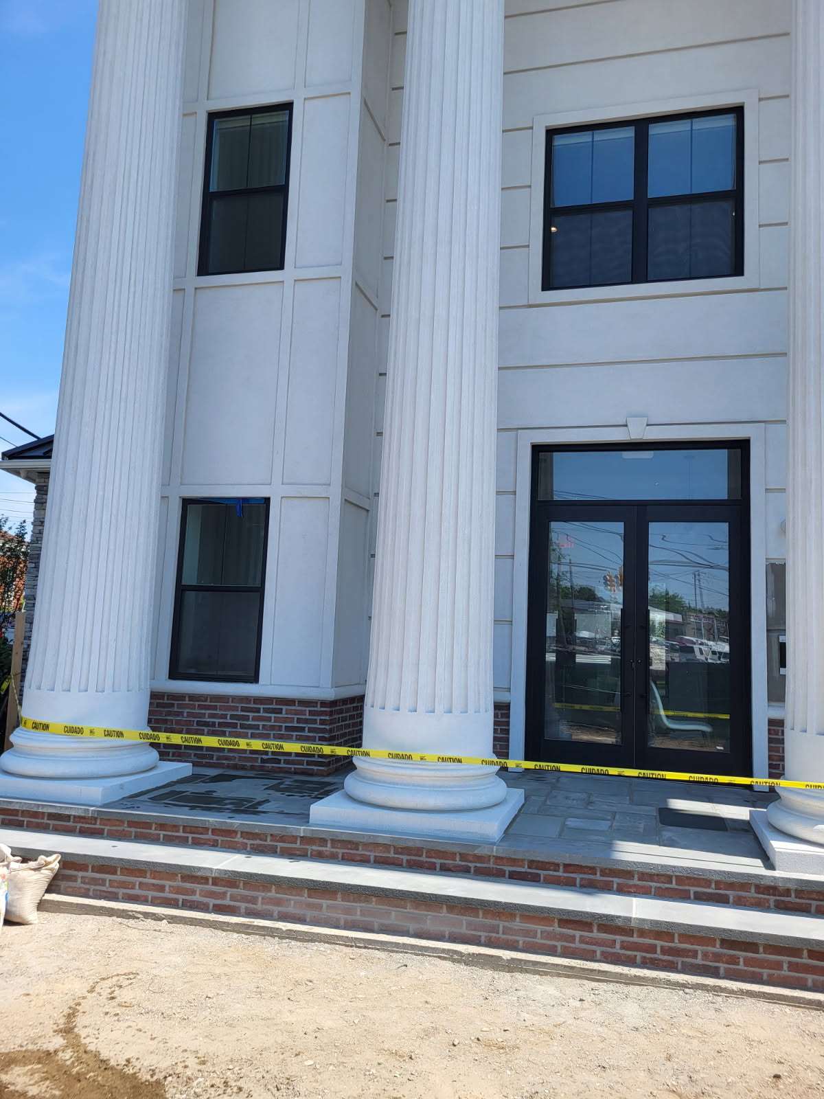 New brick steps and stone treads at a columned building entrance by Forte Brick and Concrete