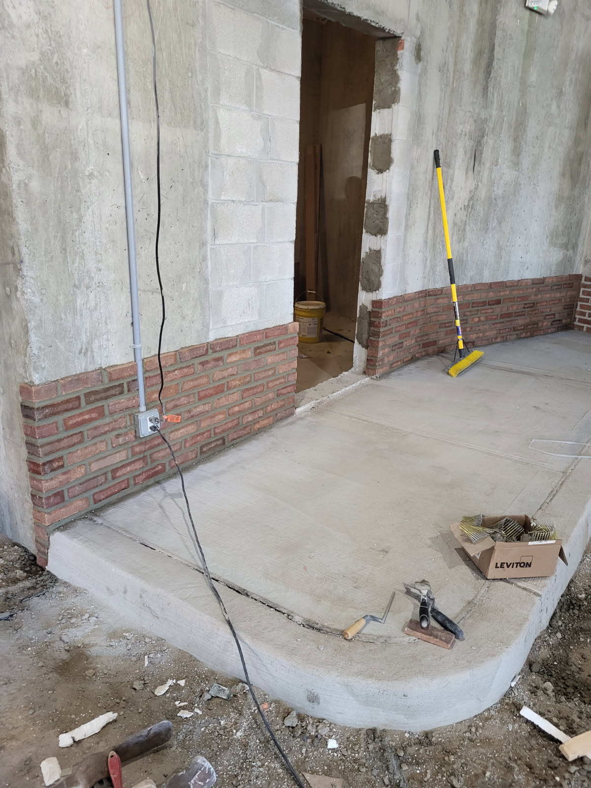 New red brick veneer wainscot laid along a concrete wall by Forte Brick and Concrete